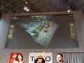 A photo from during JAEPO 2015, panel screen shows gameplay footage.